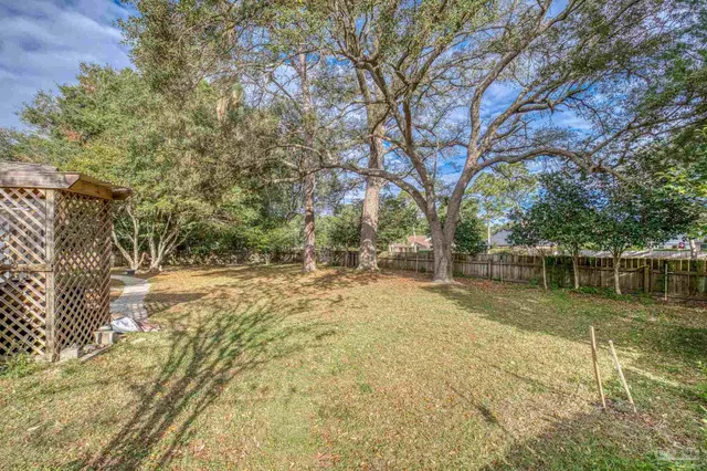 a view of a yard with wooden fence