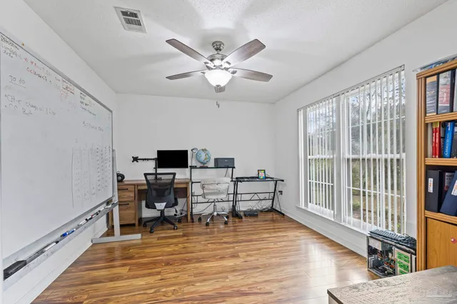 a view of a workspace with furniture and a window