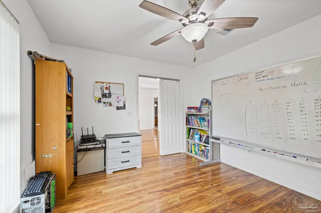 a view of a bedroom with wooden floor and closet