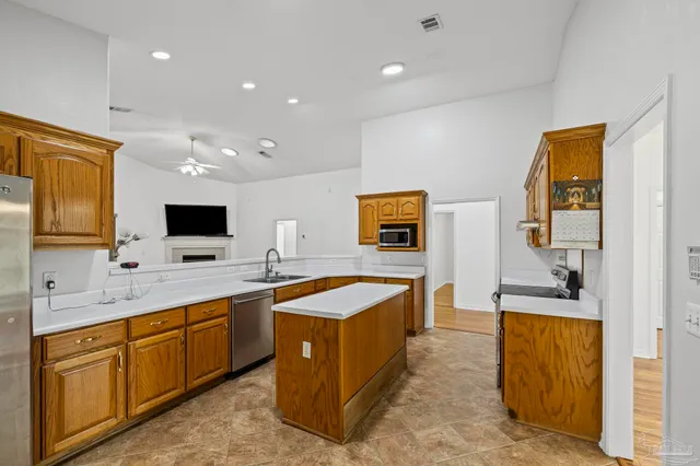 a large kitchen with stainless steel appliances granite countertop a sink and cabinets
