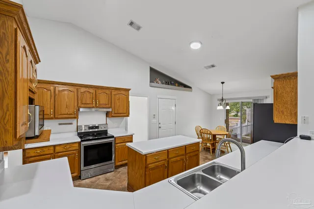 a kitchen with stainless steel appliances kitchen island granite countertop a sink and cabinets
