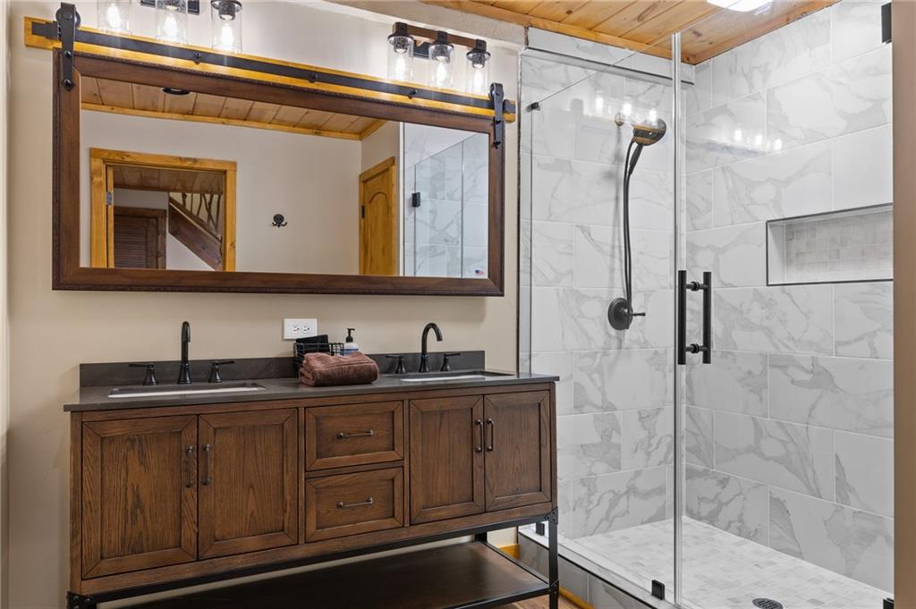 454 High Country Lane Morganton, GA 30560 - Photo 62 of 79 a bathroom with a granite countertop sink a mirror and shower
