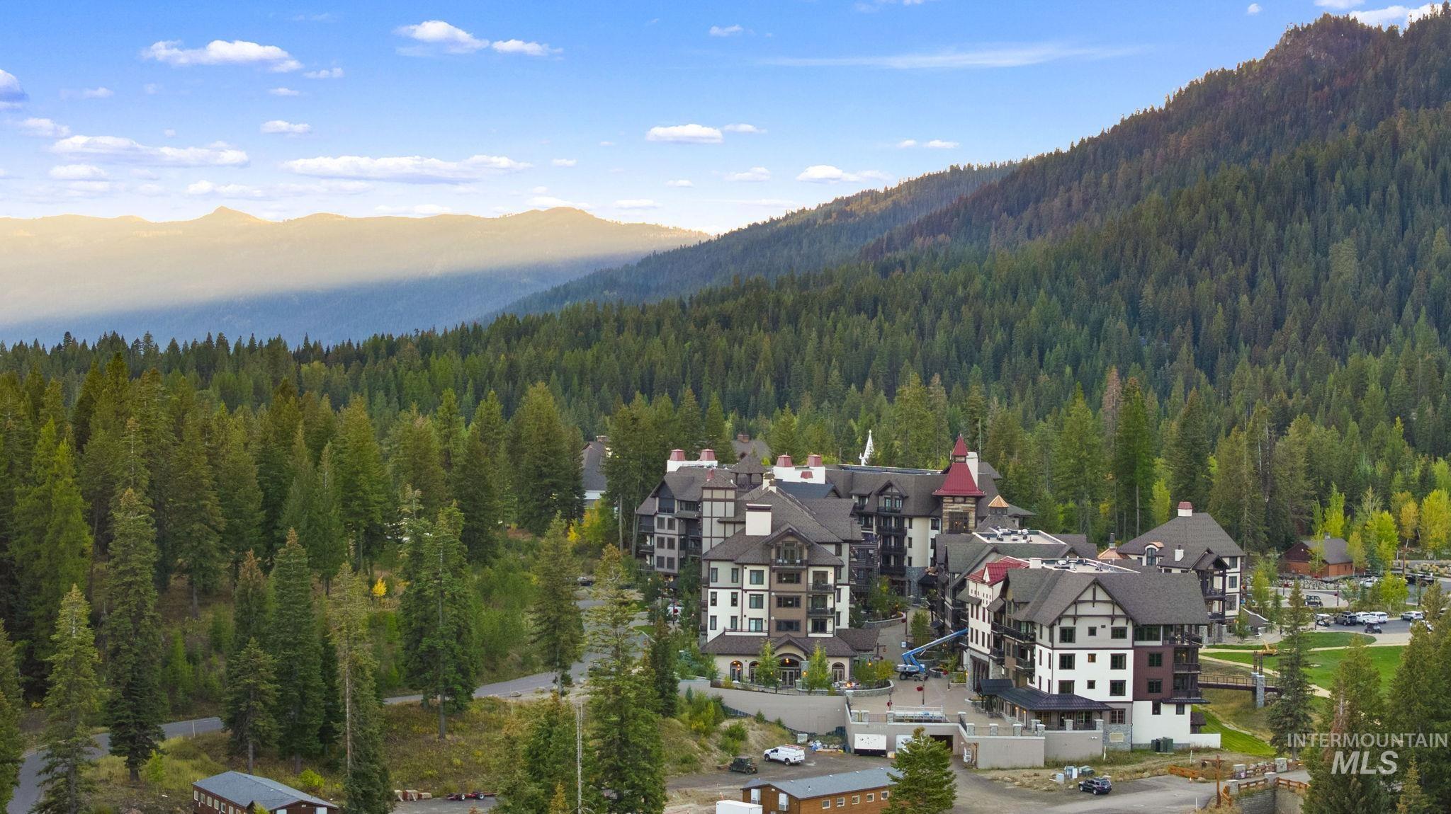 720 Village Drive, Unit 301 Donnelly, ID 83615 - Photo 31 of 43 Aerial view of residential area featuring a mountainous background and a forest