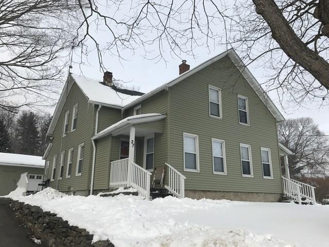 a front view of a house with a yard covered in snow