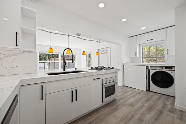 a kitchen with white cabinets and white appliances