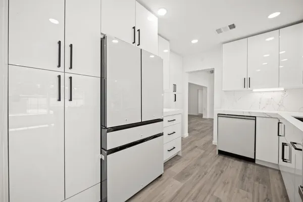 a kitchen with white cabinets and white appliances