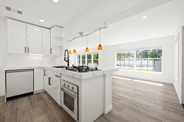 a kitchen with appliances cabinets and a wooden floor