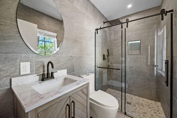 a bathroom with a granite countertop sink toilet and shower