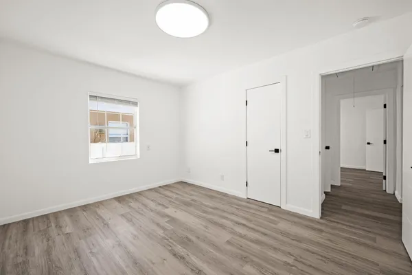 a view of an empty room with wooden floor