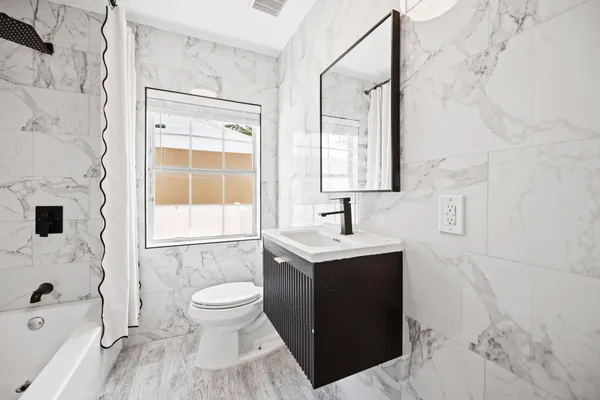 a bathroom with a sink toilet a shower and a mirror