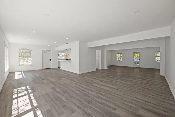 a view of empty room with window and wooden floor