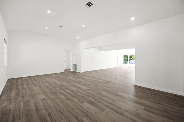 a view of empty room with wooden floor