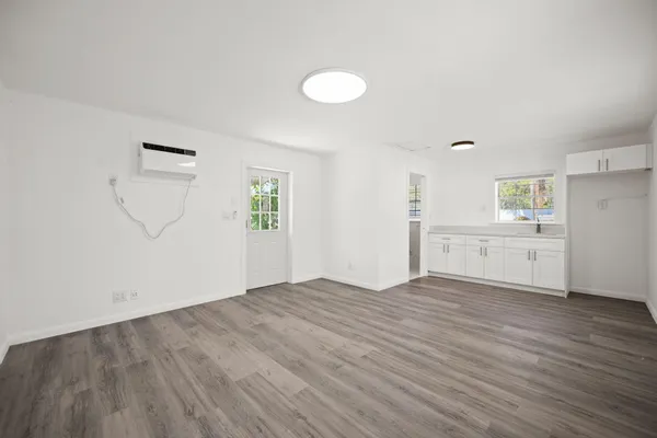 an empty room with wooden floor and windows