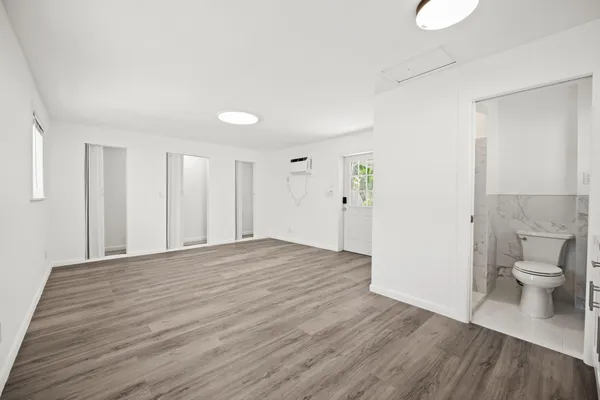 a view of a room with wooden floor and toilet