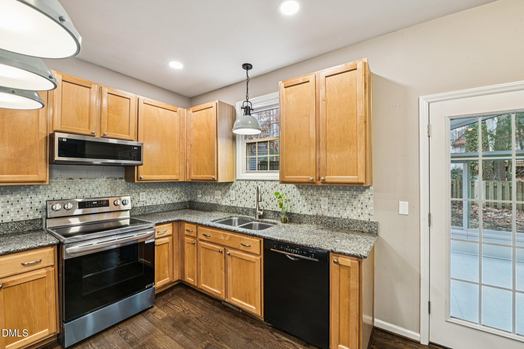 13100 Townfield Drive Raleigh, NC 27614 - Photo 11 of 31 a kitchen with stainless steel appliances granite countertop a sink stove cabinets and wooden floor