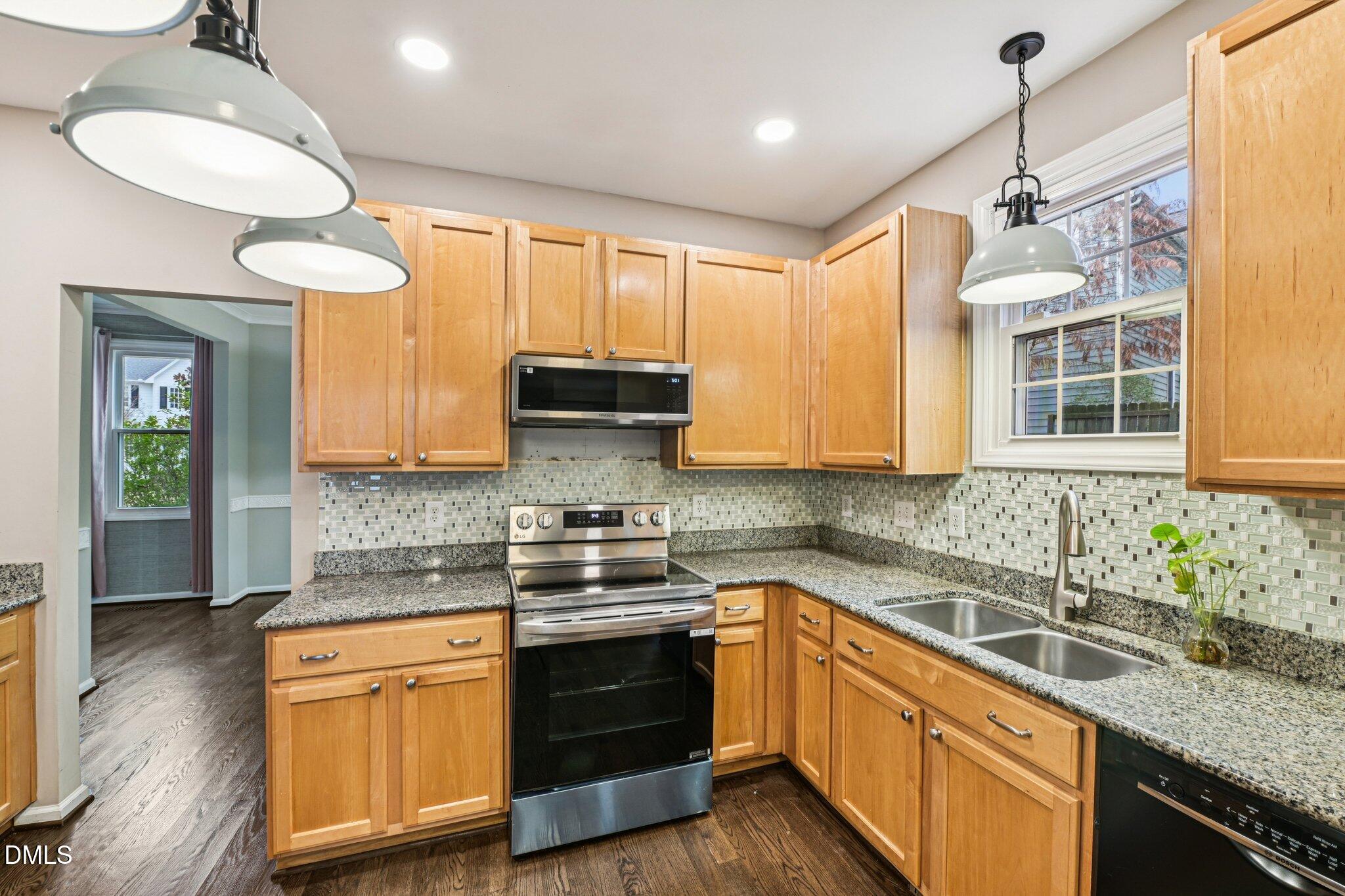 13100 Townfield Drive Raleigh, NC 27614 - Photo 10 of 31 a kitchen with stainless steel appliances granite countertop wooden cabinets a stove a sink and dishwasher