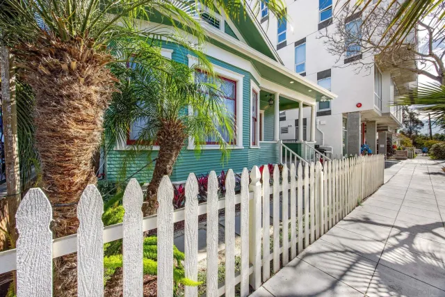 a street view of a house with wooden fence
