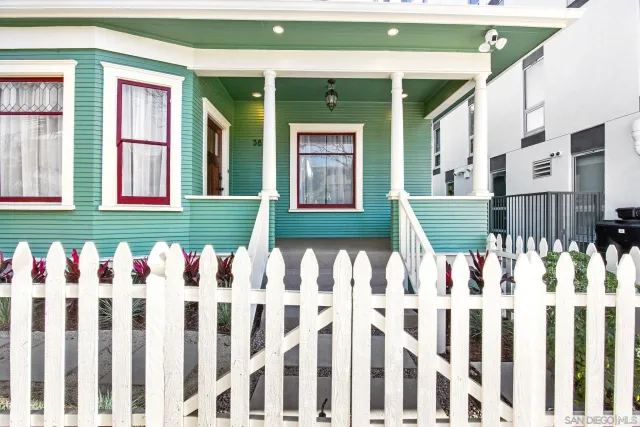 a front view of white house with a garden