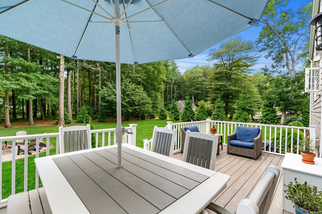 1 Valley Path Marshfield, MA 02050 - Photo 25 of 28 a view of a patio with a dining table and chairs under an umbrella