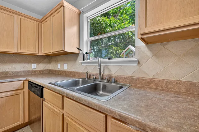 a kitchen with stainless steel appliances granite countertop white cabinets granite counter tops and a window