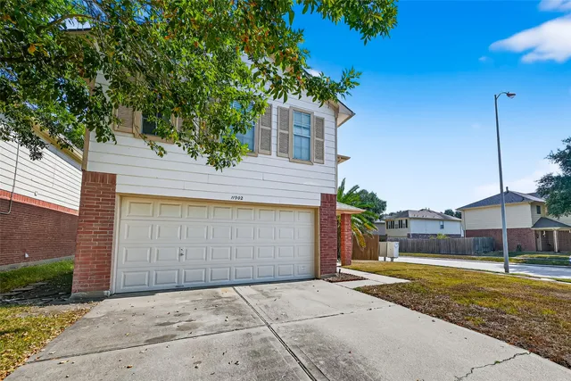 a view of a house with a yard and large tree