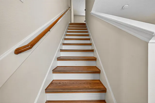 an empty room with wooden floor closet and fan