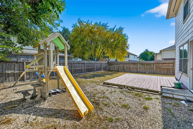 a view of a tennis ground with large trees
