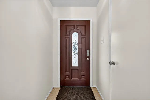 a view of a hallway with wooden floor and a living room