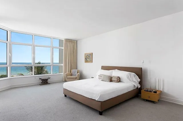 a bedroom with a bed and a large window