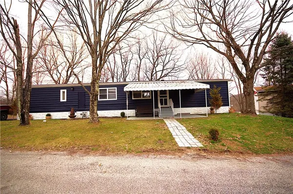 a front view of a house with a yard and trees