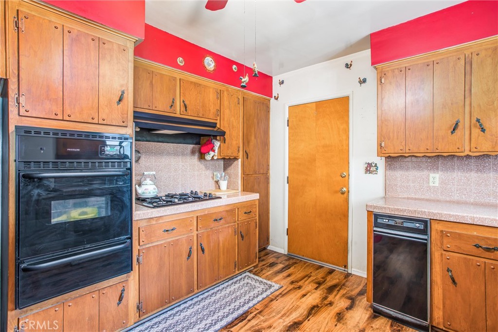 217 Syllmar Circle Calimesa, CA 92320 - Photo 11 of 28 a kitchen with granite countertop cabinets stainless steel appliances and wooden cabinets
