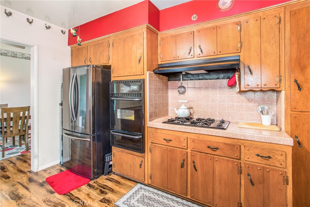 217 Syllmar Circle Calimesa, CA 92320 - Photo 13 of 28 a kitchen with stainless steel appliances granite countertop a refrigerator and cabinets