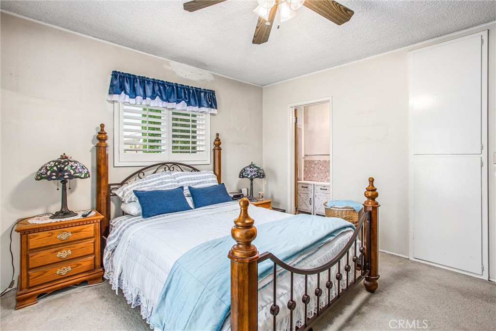 217 Syllmar Circle Calimesa, CA 92320 - Photo 18 of 28 a bedroom with a bed and a chandelier