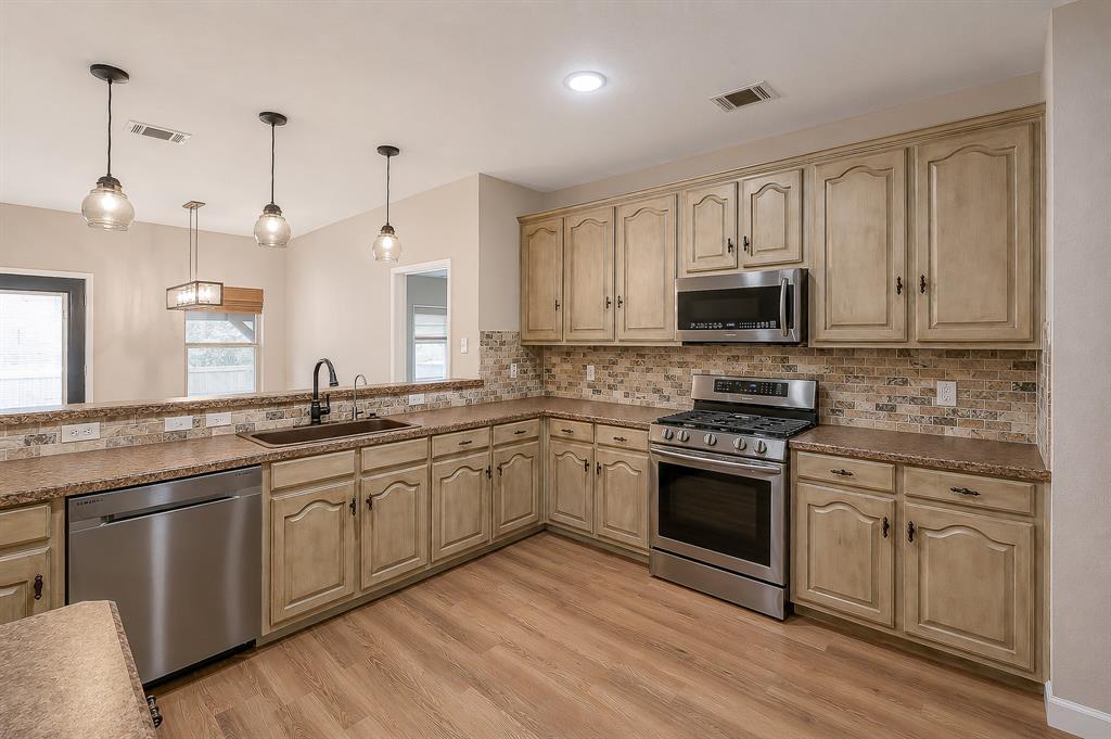 1070 Shepard Lane Lavon, TX 75166 - Photo 13 of 29 a kitchen with stainless steel appliances granite countertop a stove top oven a sink and white cabinets