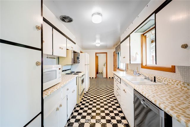 a large kitchen with kitchen island granite countertop a sink and a refrigerator