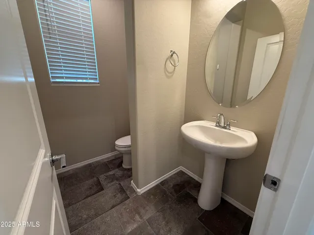 a bathroom with a sink toilet and a mirror