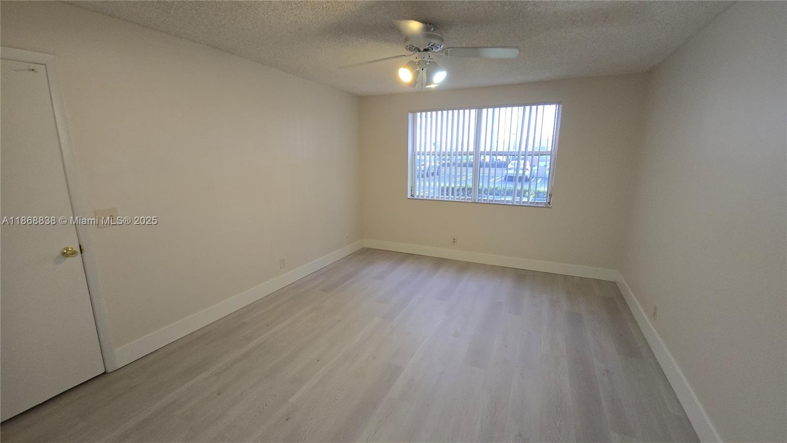 8851 Wiles Road, Unit 103 Coral Springs, FL 33067 - Photo 13 of 23 wooden floor in an empty room with a window
