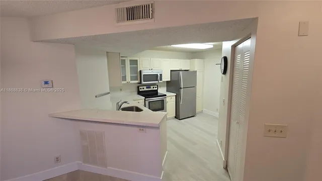 a kitchen with kitchen island a sink appliances and cabinets