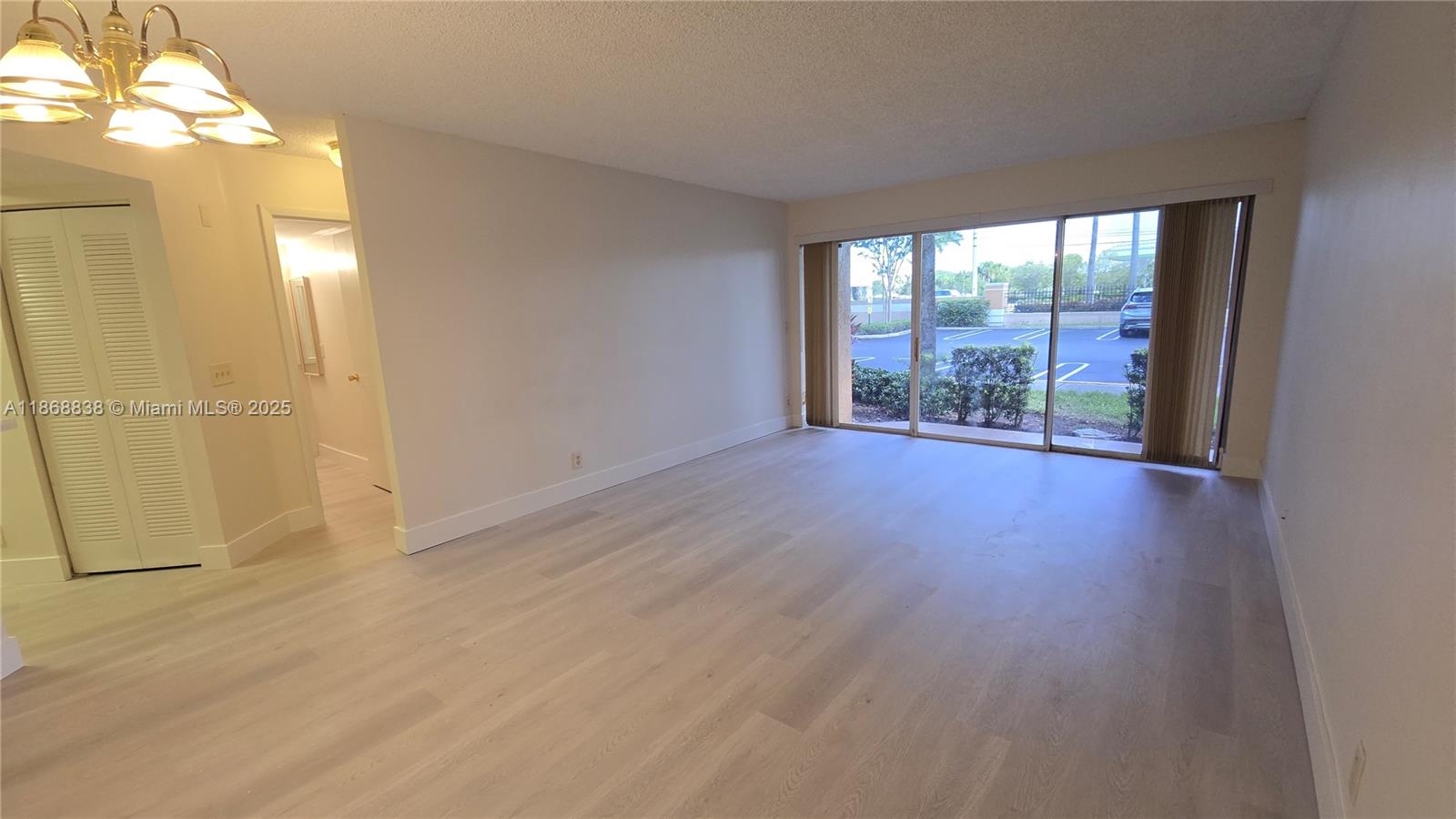 8851 Wiles Road, Unit 103 Coral Springs, FL 33067 - Photo 10 of 23 an empty room with wooden floor and windows