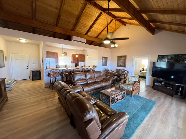 a living room with furniture a flat screen tv and next to a window