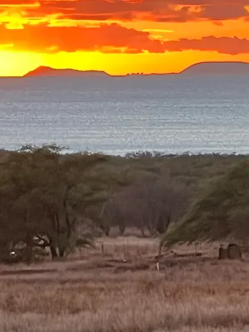 a view of mountain with sunset in background