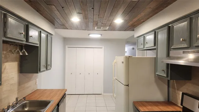 a view of a refrigerator in kitchen and an empty room