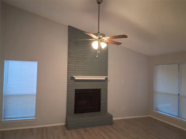 a living room with a fireplace and a ceiling fan