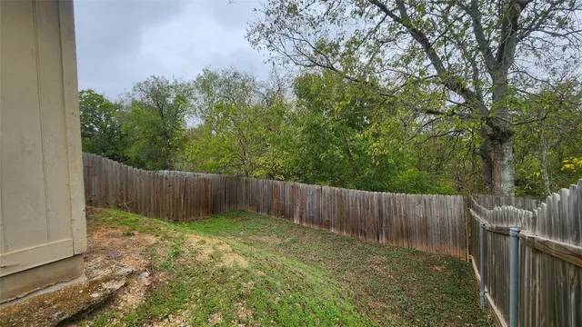 a view of a backyard with a small cabin and wooden fence