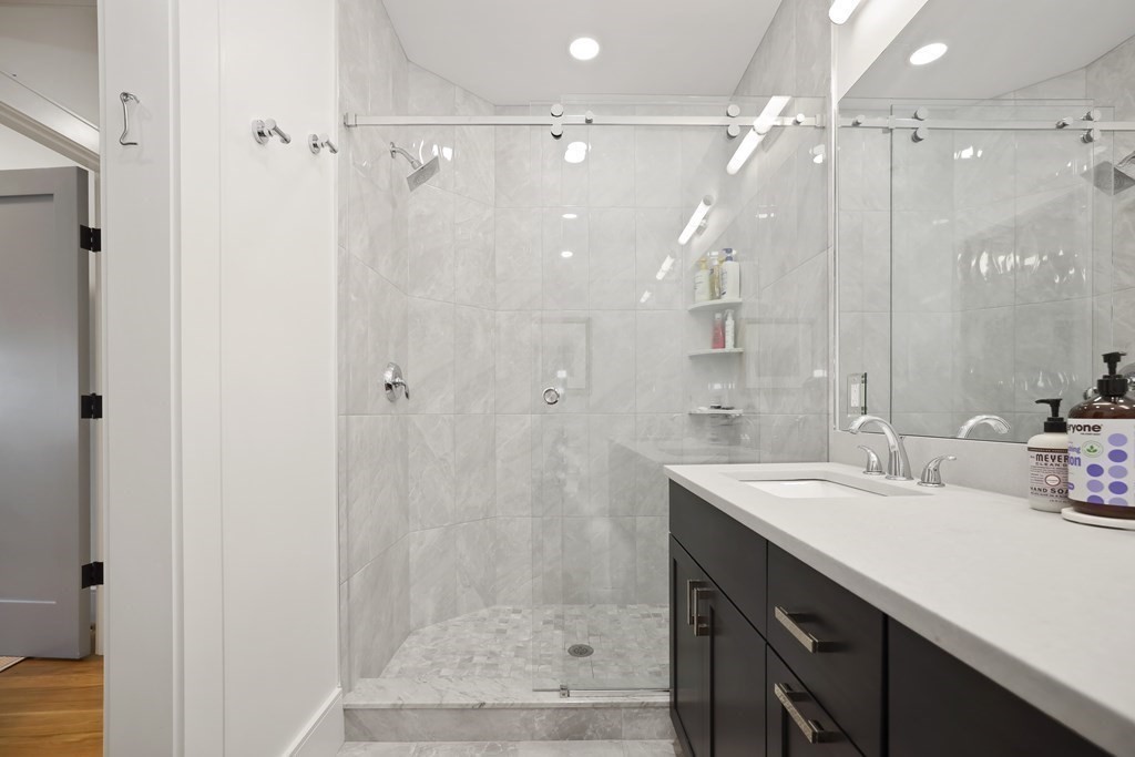 49 Boylston Street Boston, MA 02130 - Photo 13 of 36 a bathroom with a shower sink vanity and a mirror
