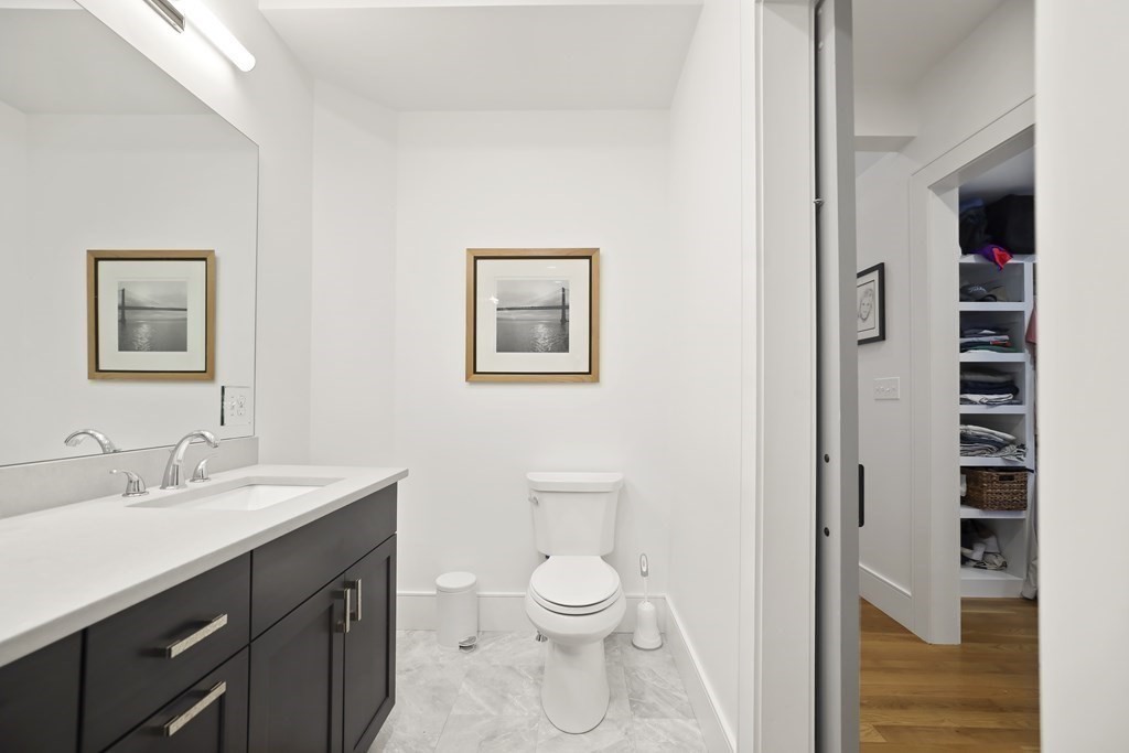 49 Boylston Street Boston, MA 02130 - Photo 14 of 36 a bathroom with a toilet a sink a vanity and mirror