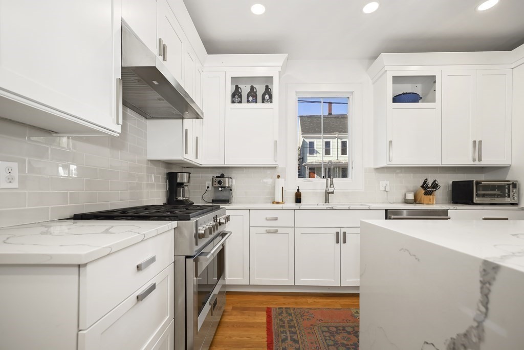 49 Boylston Street Boston, MA 02130 - Photo 6 of 36 a kitchen with stainless steel appliances granite countertop a stove a sink and white cabinets