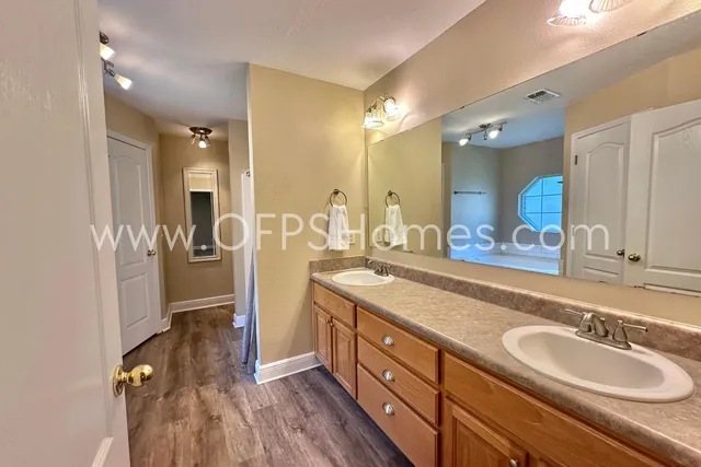 a spacious bathroom with a double vanity sink a mirror and shower