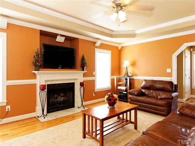 149 Alfred Court Raleigh, NC 27603 - Photo 4 of 24 a living room with furniture a flat screen tv and a fireplace