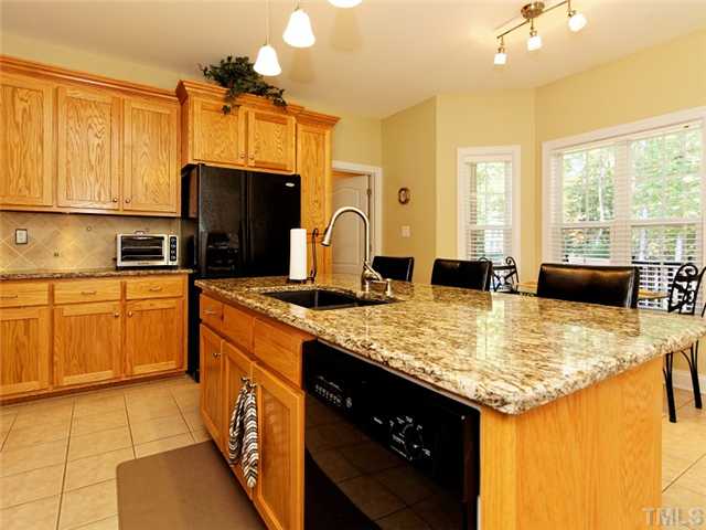 149 Alfred Court Raleigh, NC 27603 - Photo 7 of 24 a kitchen with kitchen island granite countertop a sink stove and cabinets